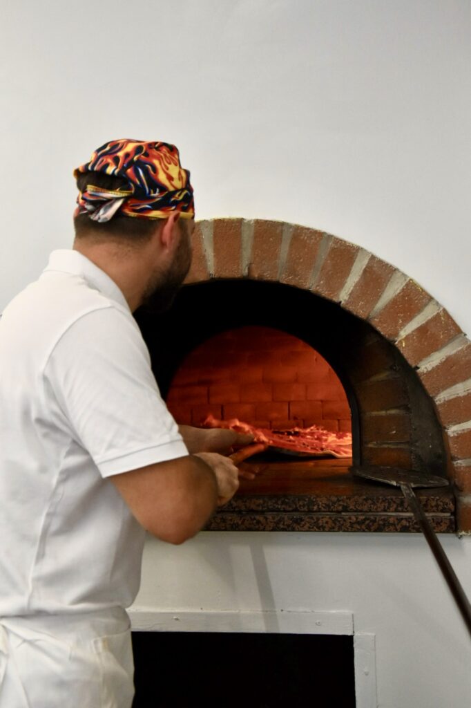 il pizzaiolo inforna la pizza